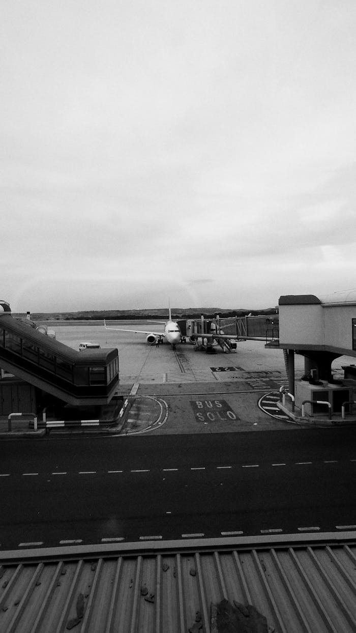 gallery-5 A monochrome scene capturing an airplane on the tarmac at Madrid Airport.